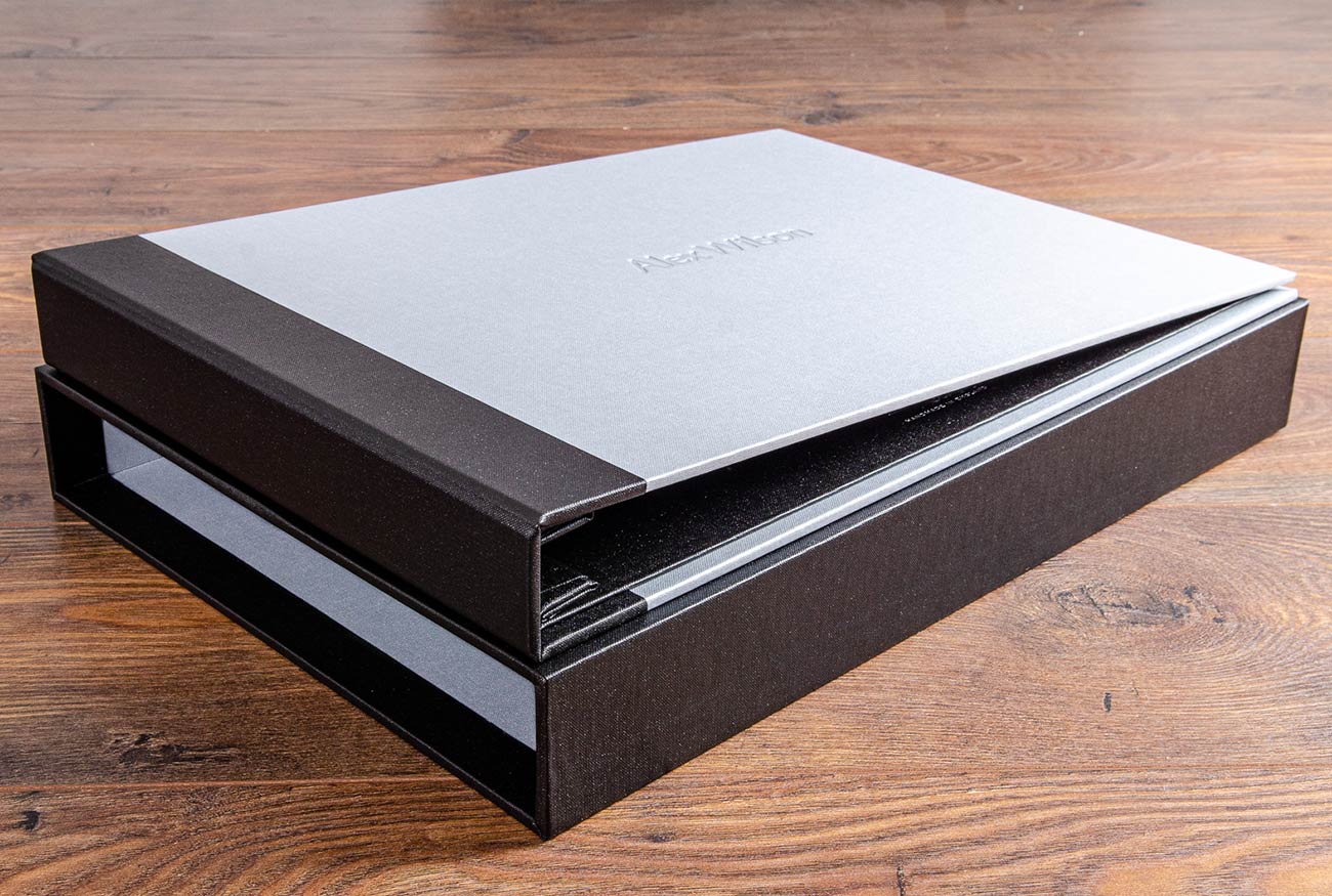 A3 photographers portfolio book and matching slipcase, Product - A3 case bound screw post binder. Material - Platinum buckram cover and charcoal buckram spine cover with blind debossed personalised cover. Slipcase in charcoal buckram with inner lining