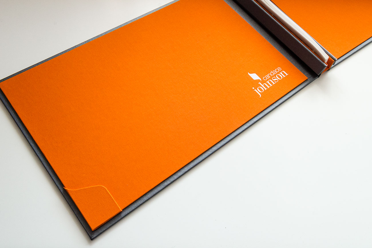 Inner cover of designers portfolio book with bespoke business card holder and white foil personalization