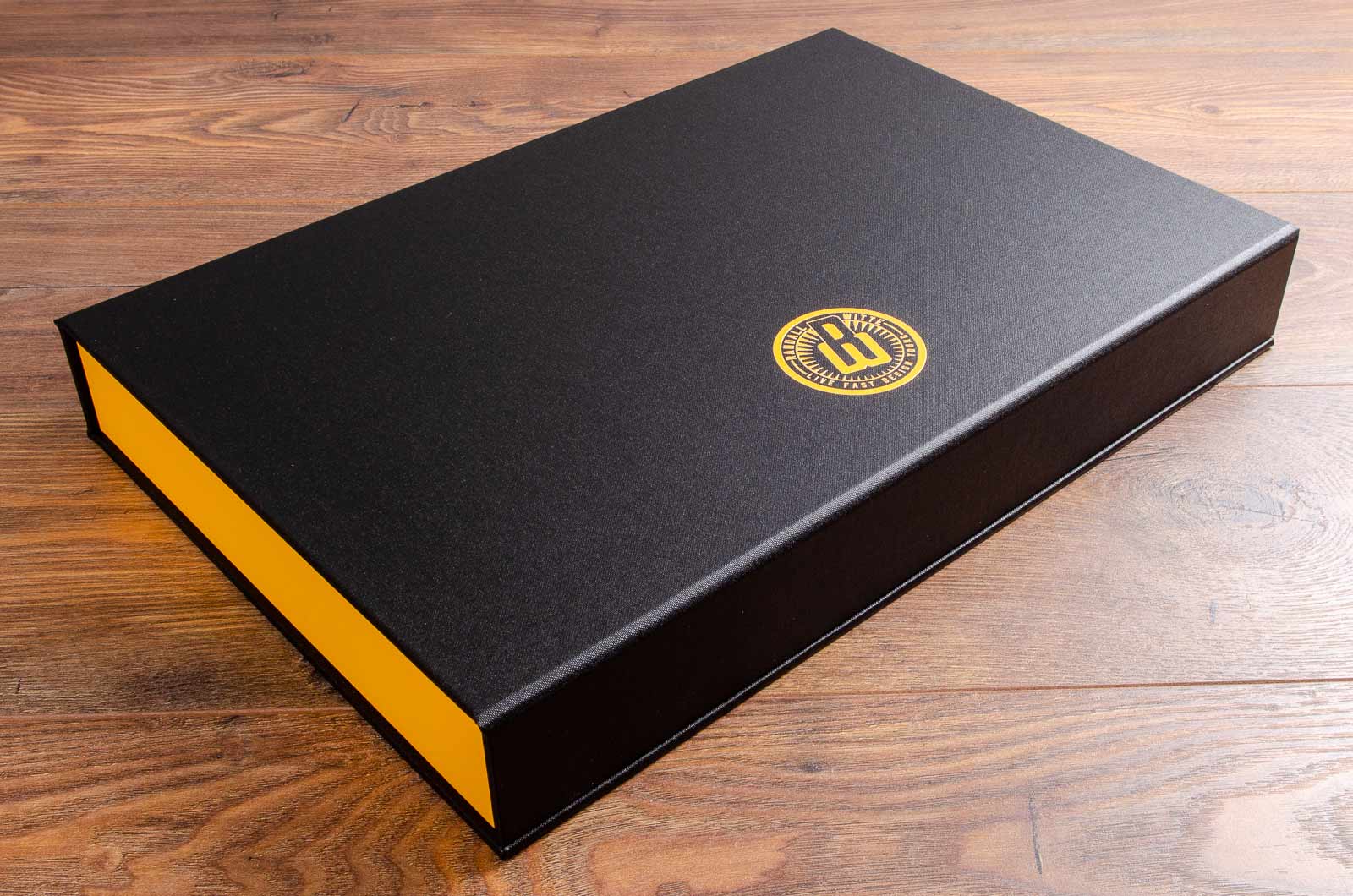 Portfolio box. Product - Dropback clamshell box. Size is 11x17 inches. Colour is black buckram and yellow buckram. Personalisation is full colour UV printing
