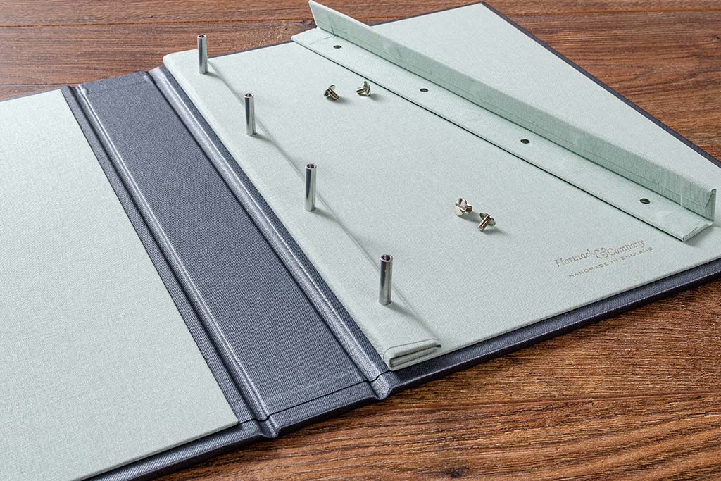 Once you have undone the screw heads, lift off the cover and simply place your page into the portfolio.