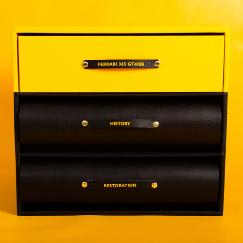 Yellow and black box with 'Ferrari 365 GT4/BB' and 'History Restoration' text on a yellow background