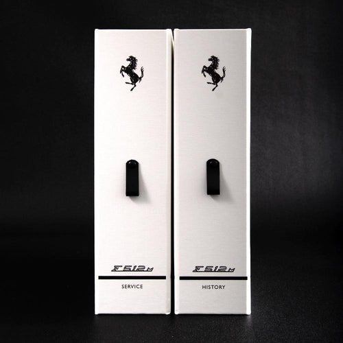 Two white boxes for car history and service with black Ferrari logo  on a black background