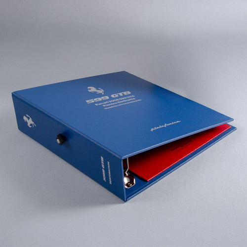 Blue luxury ring binder personalised with red interior on a gray background