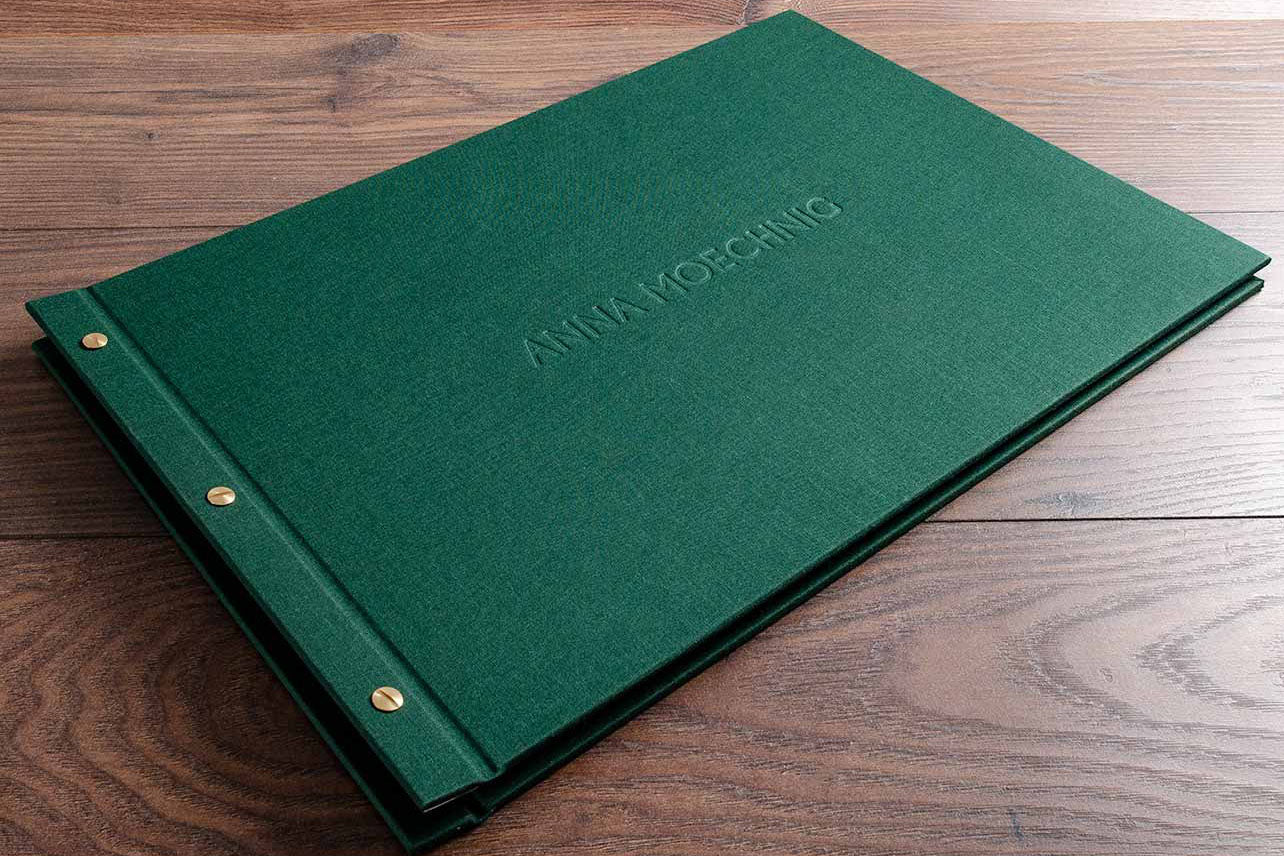 11x17 portfolio book. Product is an Exposed screw post binder personalised with blind embossed stamping. Material is green book cloth