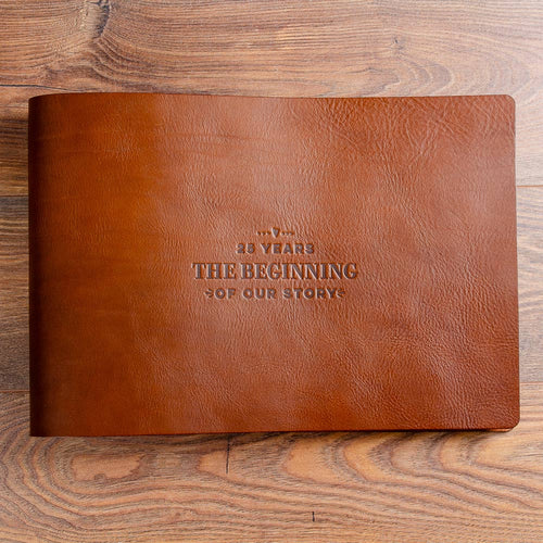 large rustic brown leather landscape anniversary album on wood background