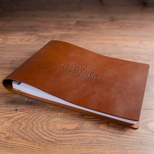 large brown rustic leather wedding anniversary album with screw posts and paper inserted.