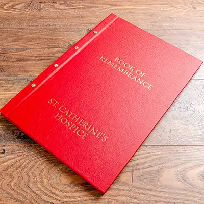 luxury red leather A3 screw post binder with gold foil embossing  on the cover sitting on a wood background