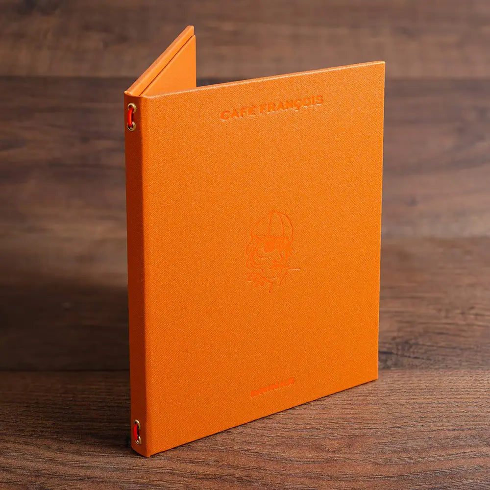 small A5 menu cover with elastic strap in orange buckram and orange foil embossing on the cover