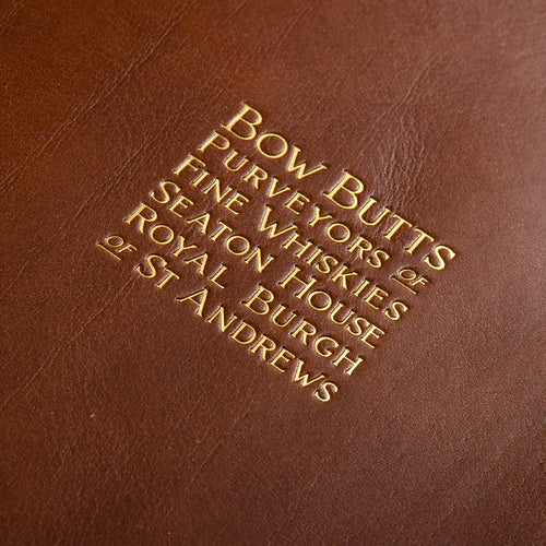 Gold foil lettering embossed into a brown leather menu cover