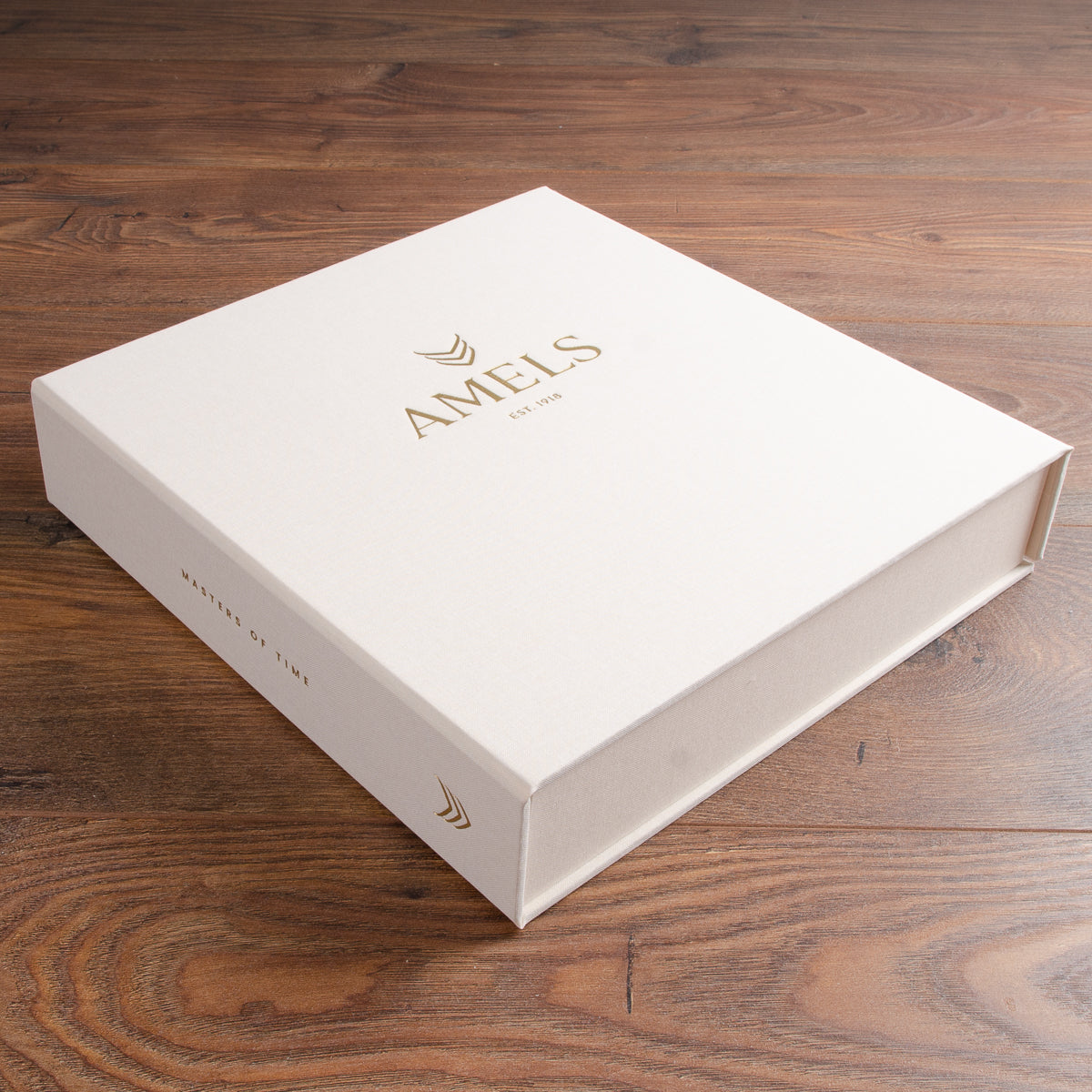 Luxury clamshell presentation box in cream fabric material with gold foil embossing on the cover and spine 