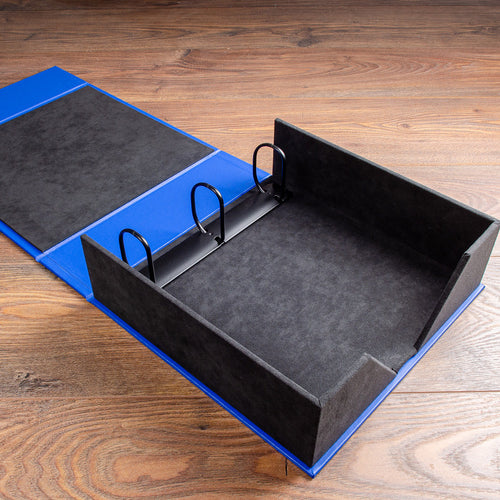 black suede 3 ring box file with blue cover on wooden floor