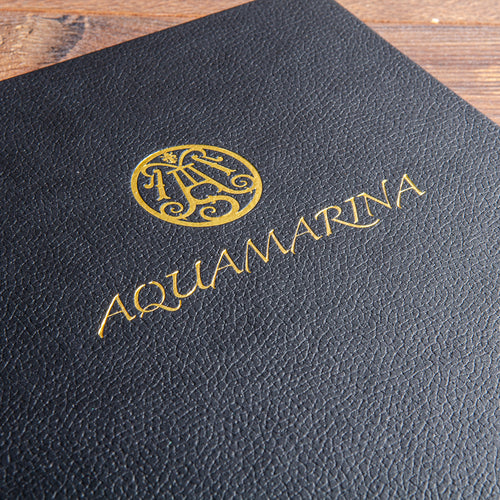 Gold embossed logo on black faux leather menu board