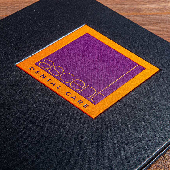 luxury custom made presentation binder with intricate orange and purple logo name plaque
