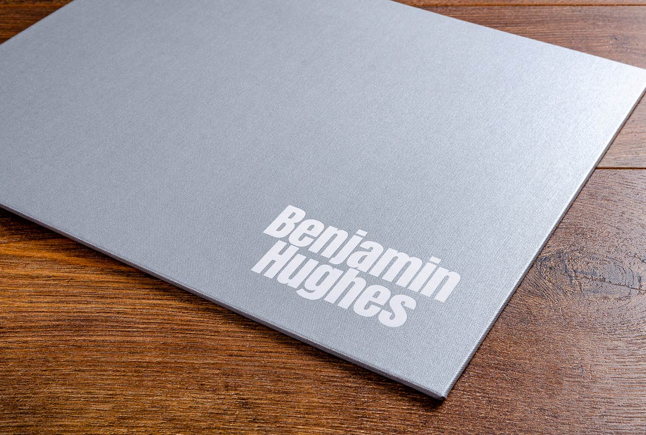 Personalised cover of A3 photography portfolio book. Material is Platinum silver buckram personalised with white foil embossing
