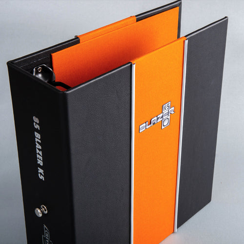 custom made black leather ring binder with orange and chrome detailing and sliver badge inserts for car history