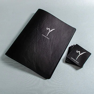A black genuine leather A4 binder menu cover with silver foil personalised cover and square leather personalised coaster matts