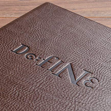 Blind embossed logo on the cover of a brown menu cover