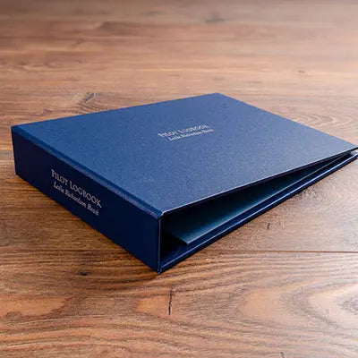 landscape blue buckram ring binder with personalised cover and spine with the words pilot logbook foiled.