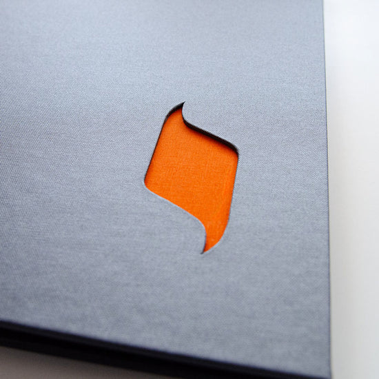 close up of a cut out logo shape in the cover of a portfolio book
