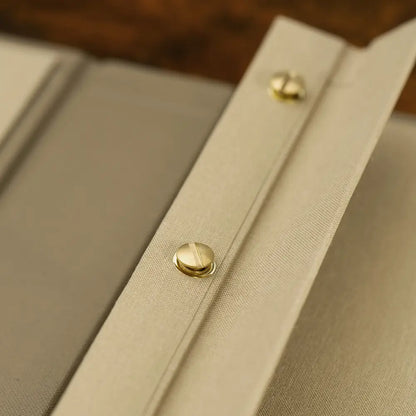 close up of Screw Post Binder in luxury fabric with bespoke gold screw post mechanism by Hartnack and Company