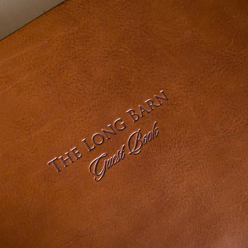 personalized lettering and logo of a guest book on a brown leather cover