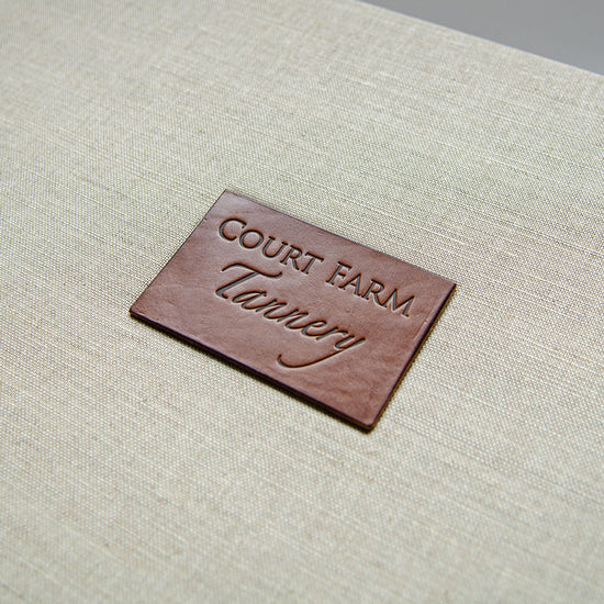 Brown leather name plaque with blind embossed logo inset into a box