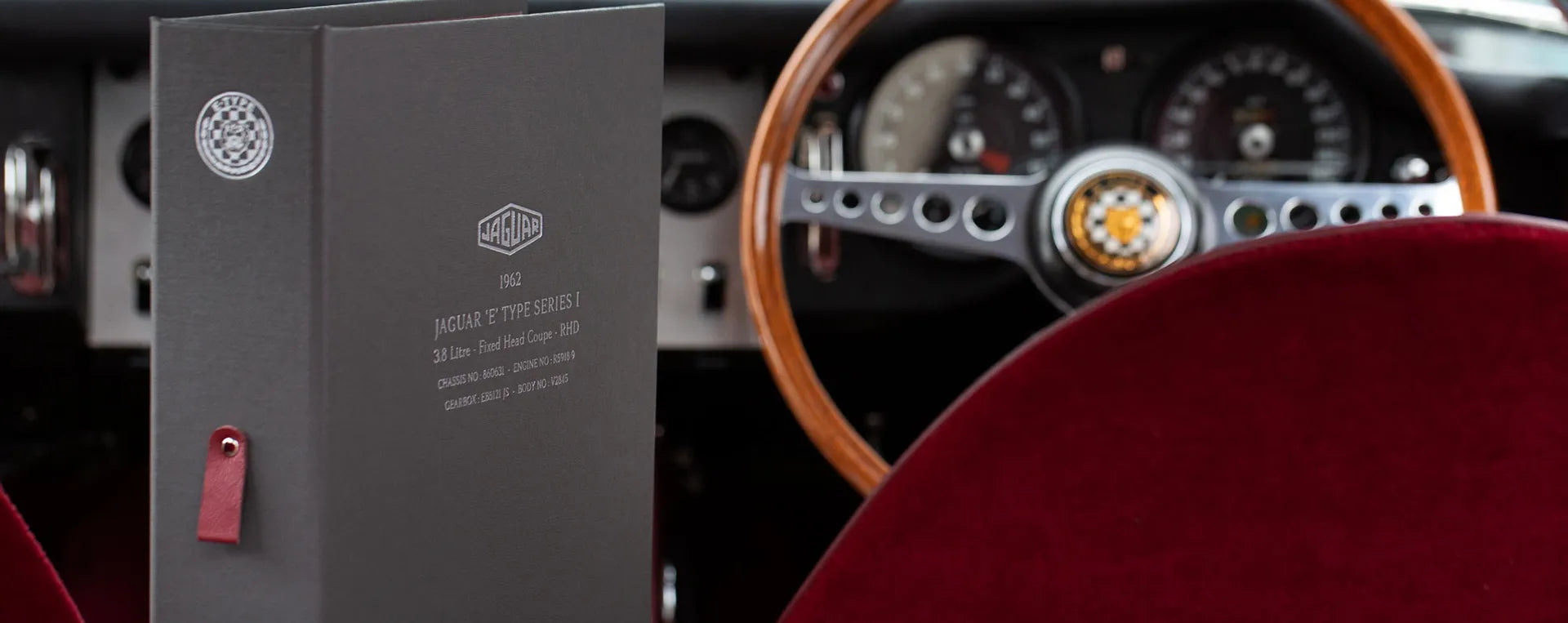 Custom made ring binder in grey with personalised cover and spine in silver foil for car history documents inside a jaguar car