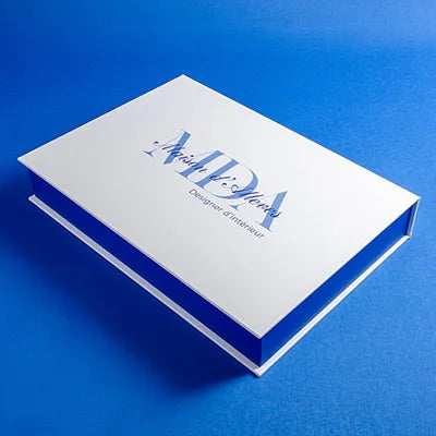 White luxury clamshell presentation box with blue logo custom printed on the cover placed on a blue background