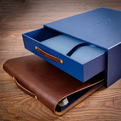 blue box with blue drawer with leather handles and a brown leather luxury album