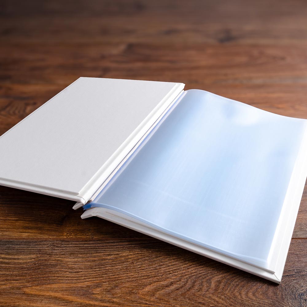 white screw post binder with plastic page pockets by hartnack and co on wood back drop - Gallery image 2