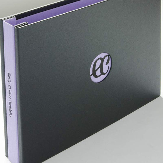 portfolio book in black and purple with a window in the cover and a black foil embossed logo and also embossed text on the spine