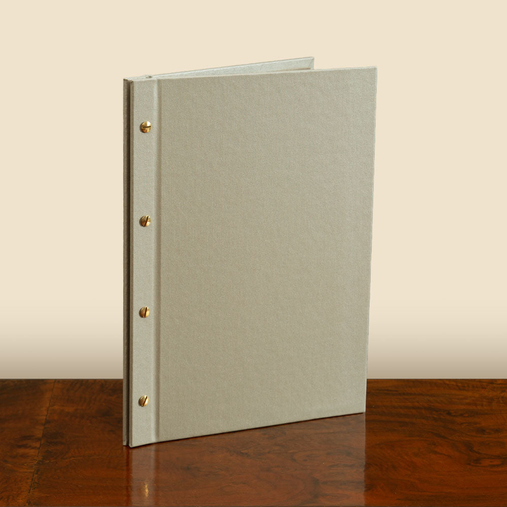 Exposed Screw Post Binder in beige fabric with gold screws, a luxury bespoke presentation binder by Hartnack and Company.