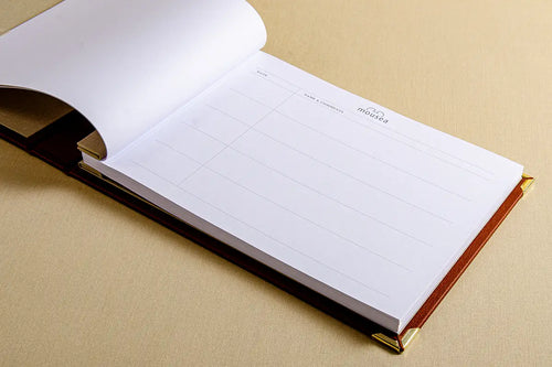 The open cover of a bespoke guest book with personalised pages with the logo of the yacht or establishment at the top of every page.