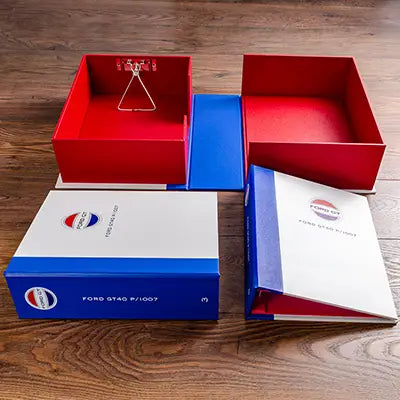 Race car document files boxes and binders for historic GT40 race car in red white and blue with logos printed on the cover and spine