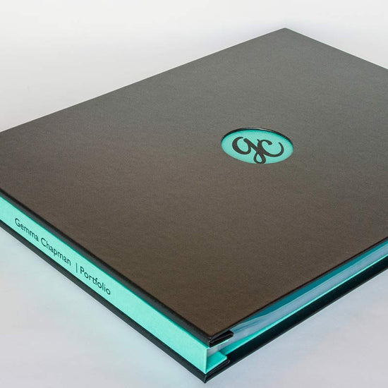 Custom made A3 portfolio book in black and green with a window in the cover and an embossed logo on the other side and also embossed text on the cover