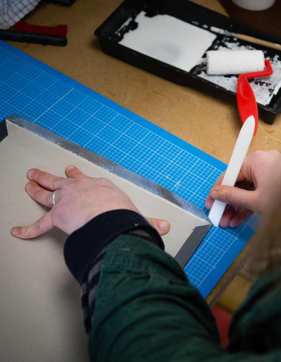 a book cover being hand made with a bone folder