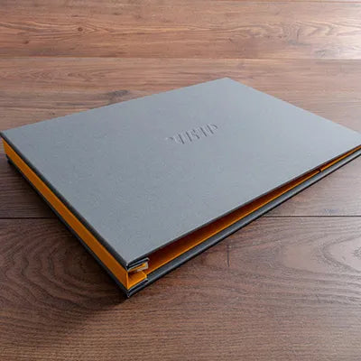 A3 landscape portfolio book in grey book cloth with yellow lining and blind debossed personalised cover