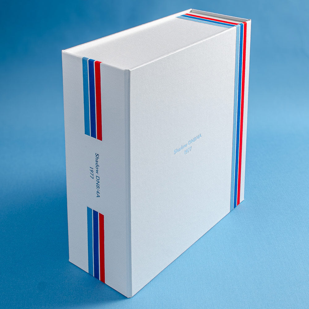 a bespoke box file in white buckram with three stripes in red, dark blue and light on the spine and the cover and the details of an F1 car silver foiled on the cover and spine - Gallery image 1