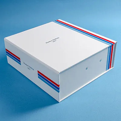 custom made box file in white cloth with red and blue pin stripes and the details a classic F1 car embossed in silver on the cover and spine