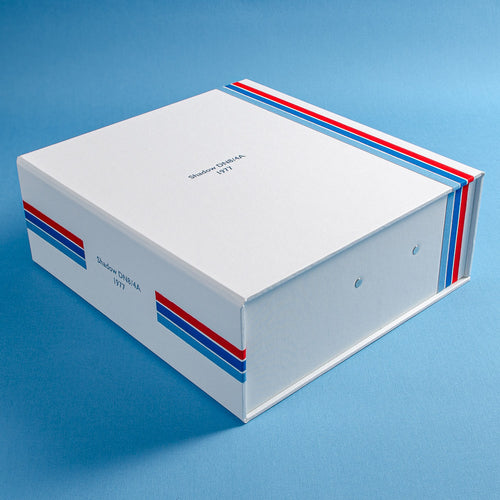 custom made box file in white cloth with red and blue pin stripes and the details a classic F1 car embossed in silver on the cover and spine