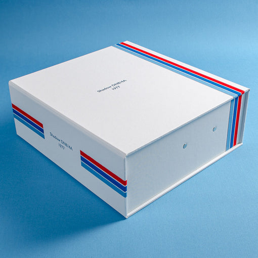 custom made box file in white cloth with red and blue pin stripes and the details a classic F1 car embossed in silver on the cover and spine