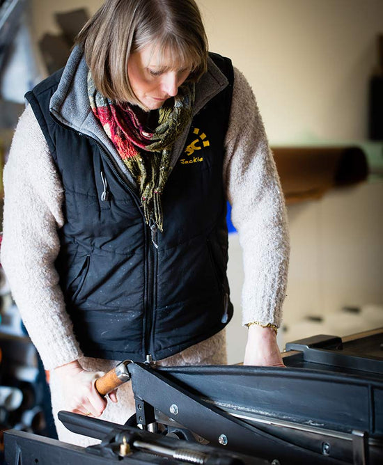 Jackie Hartnack cutting book board on her vintage guillotine board cutter