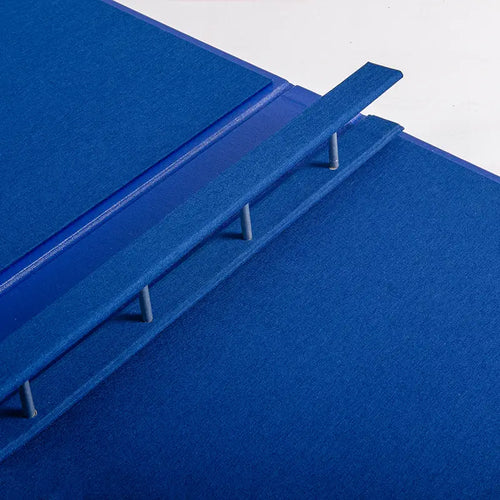 A close up of the quality of a Hartnack and Co screw post binder. The folder is in blue book cloth and is custom made.