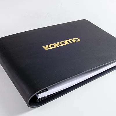 black leather book with gold foiled embossed logo on the cover custom made by hartnack and company