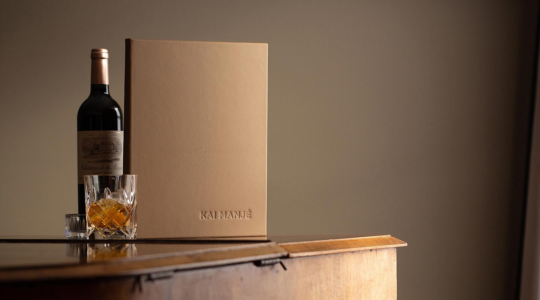 Menu cover luxury genuine leather bound and embossed menu cover sitting on piano with glass and bottle