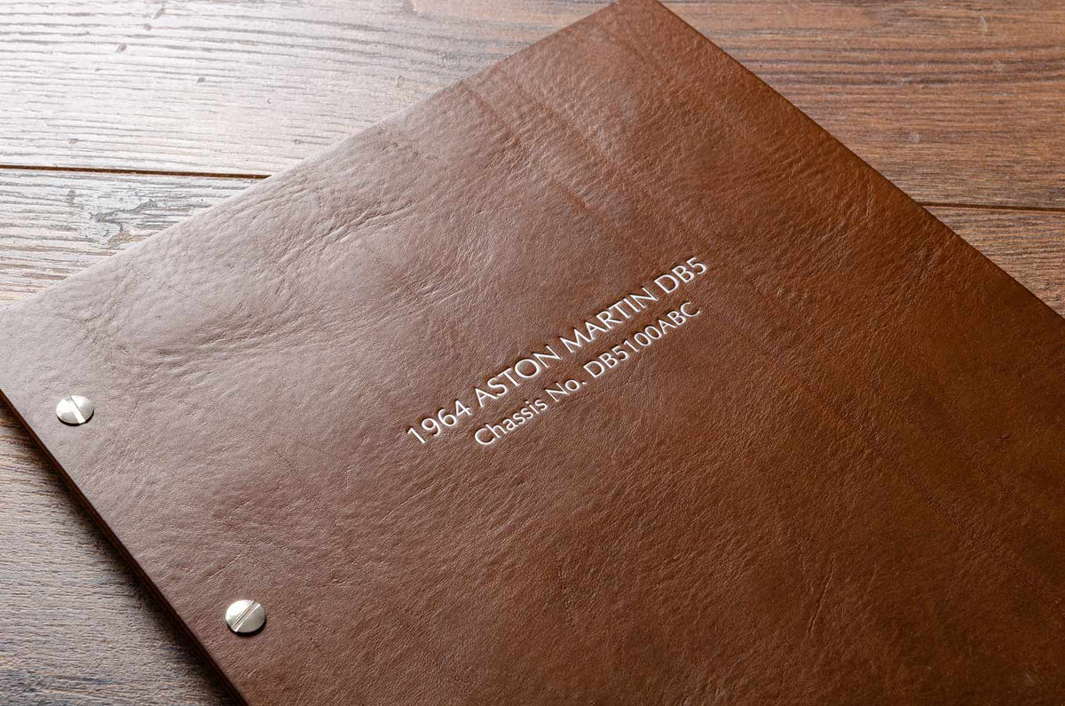 Detail of a brown leather binder with silver foil embossed writing stamped in the cover - Gallery image 2