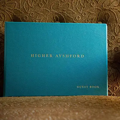 Luxury personalised leather bound guest book with gold foil embossing on the cover of a beautifully hand made product by hartnack and company