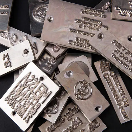 A collection of metal debossing plates for personalised binder and box covers