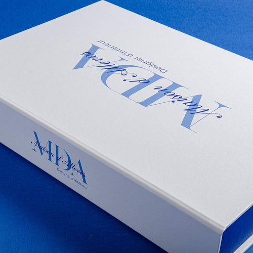 White clamshell box with blue text and logos on a blue background by hartnack and co