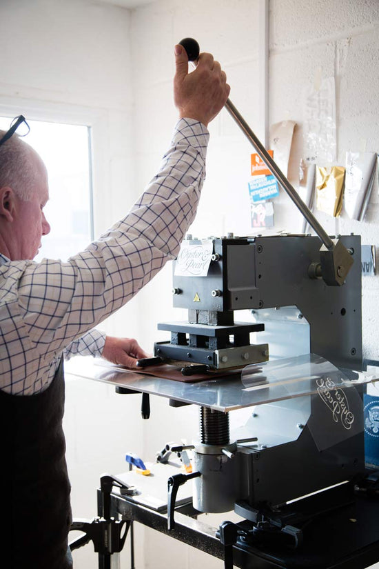 embossing a piece of leather with a hand blocking machine